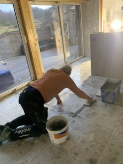 Flislegging av gulvet og rundt ovnen er utført av Murermester Arnt Kristensen.